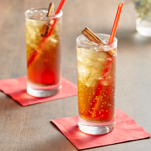 Two glasses of Tractor Beverage Co. organic light cola with cinnamon sticks and straws.