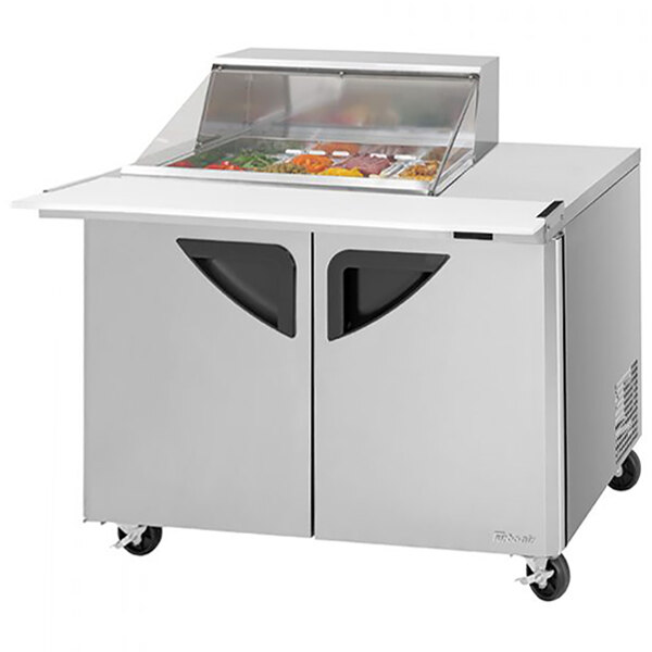 A Turbo Air stainless steel 2 door refrigerated sandwich prep table with clear lids.
