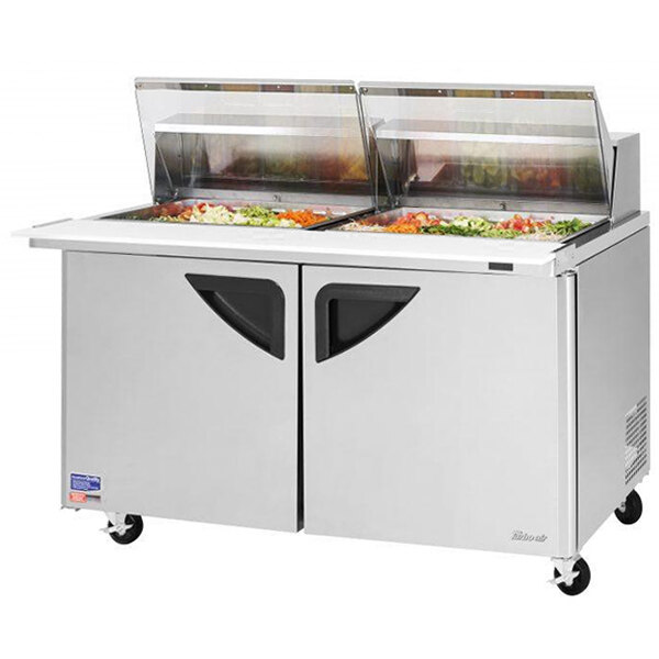 A Turbo Air sandwich prep table with clear lids on wheels.
