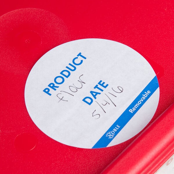 A red plastic dispenser carton of Noble Products round removable labels with a white circle and blue text.
