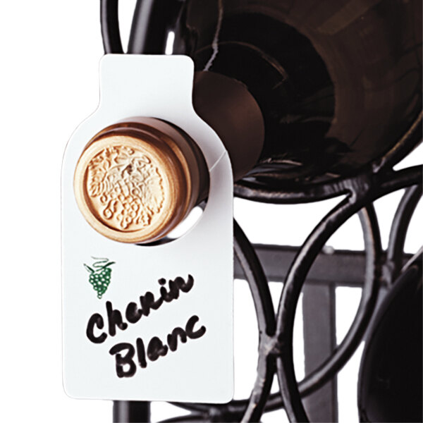 A close-up of a round brown Franmara plastic wine tag on a bottle of wine with a label that says Chateau Blanc.