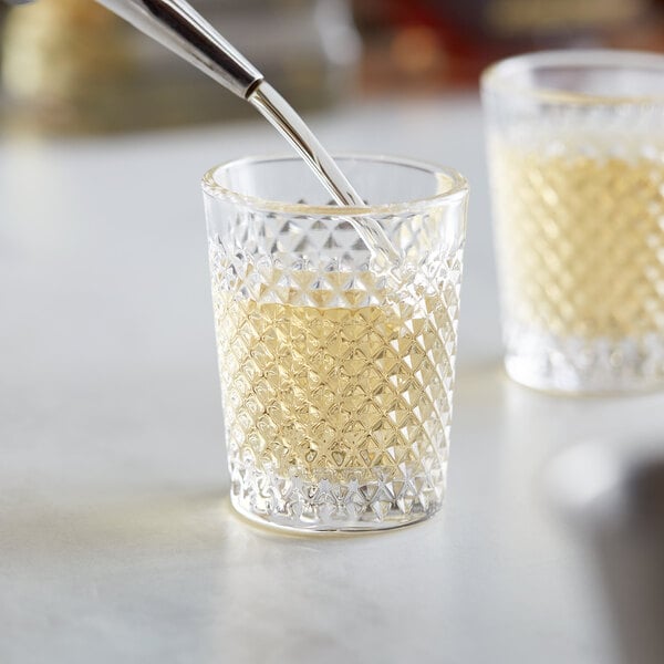 A close-up of an Acopa Aurelius shot glass filled with liquid.