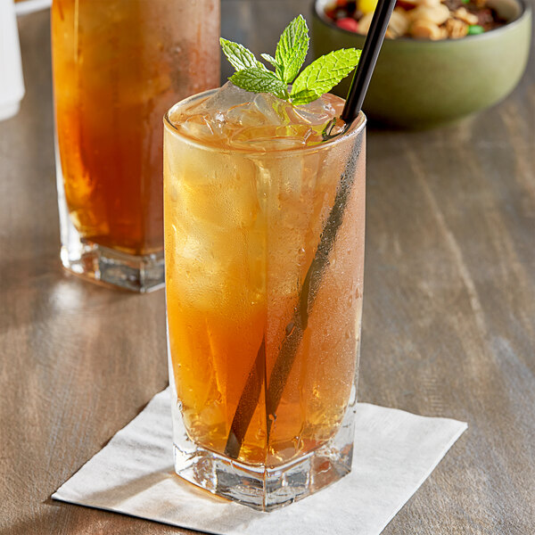 A glass of Jones iced tea with a straw and mint leaves.