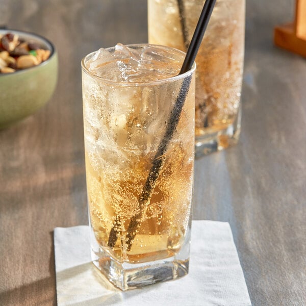 Two glasses of Jones Ginger Ale with straws on a table.
