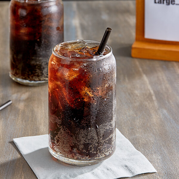 A glass of Jones Sugar-Free Cola soda with ice and a straw.