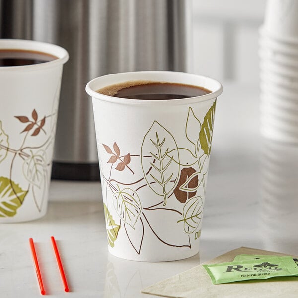 Two Dixie Pathways paper cups with lids and a tea bag on a counter.