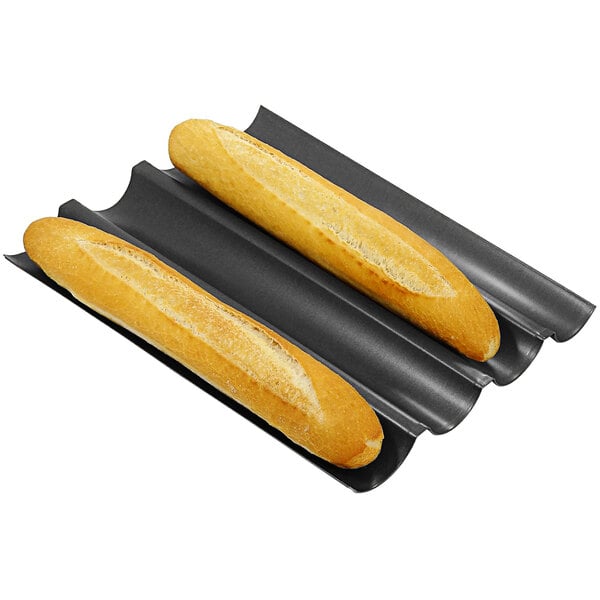A black tray with four long loaves of bread baked in the Gobel 4 Loaf Long Baguette Pan.