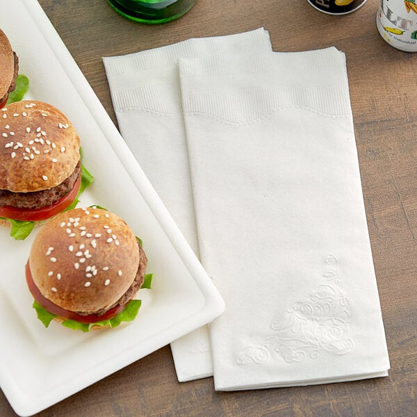 A white plate with two hamburgers and a Dixie 2-Ply paper dinner napkin.