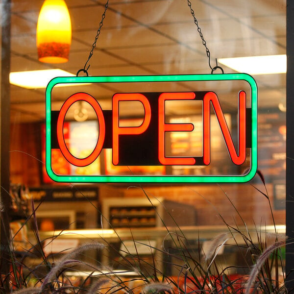 A rectangular neon sign that says "Open" with a green border.