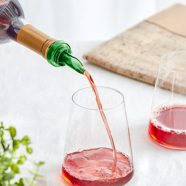A Franmara green wine pourer on a bottle pouring red wine into a glass.