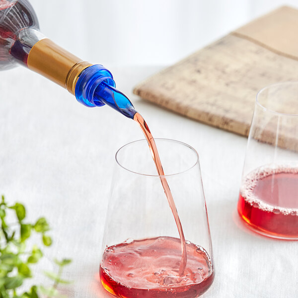 A person using a Franmara Blue Wine Pourer to pour red wine into a glass.