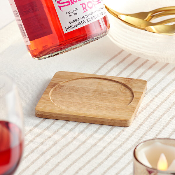 A bottle of wine on a Franmara bamboo wine coaster.