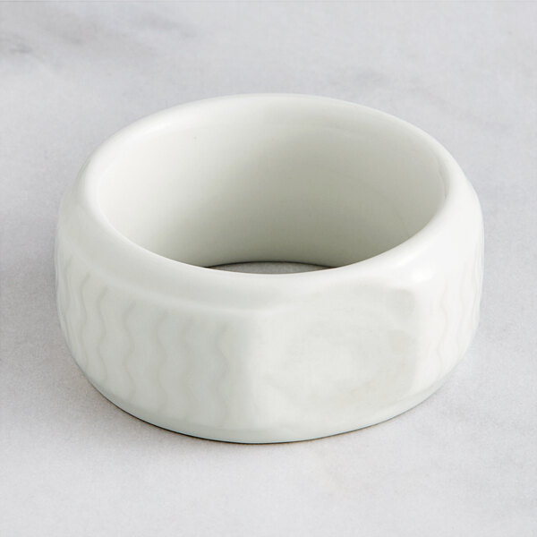 A RAK Porcelain ivory porcelain napkin ring with a curved design.