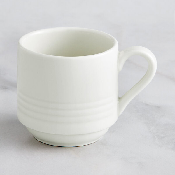 A RAK Porcelain ivory porcelain cup with a handle on a marble surface.