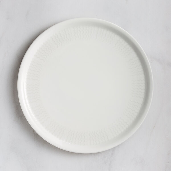 A RAK Porcelain ivory porcelain pizza plate with an embossed pattern.