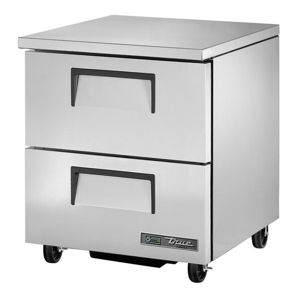 A stainless steel True undercounter freezer with two drawers and black handles.