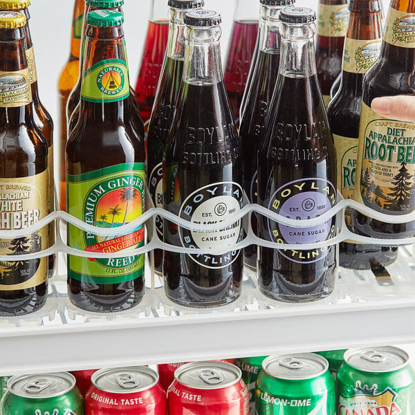 An Avantco bottle lane organizer filled with soda and beer bottles.