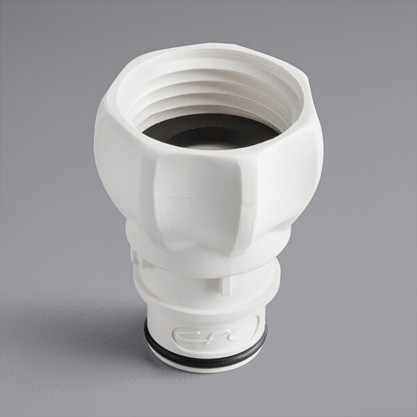 A white plastic pipe fitting with a black circle.