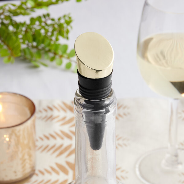 A wine bottle with a Franmara rubber stopper with a gold-plated top on a table.