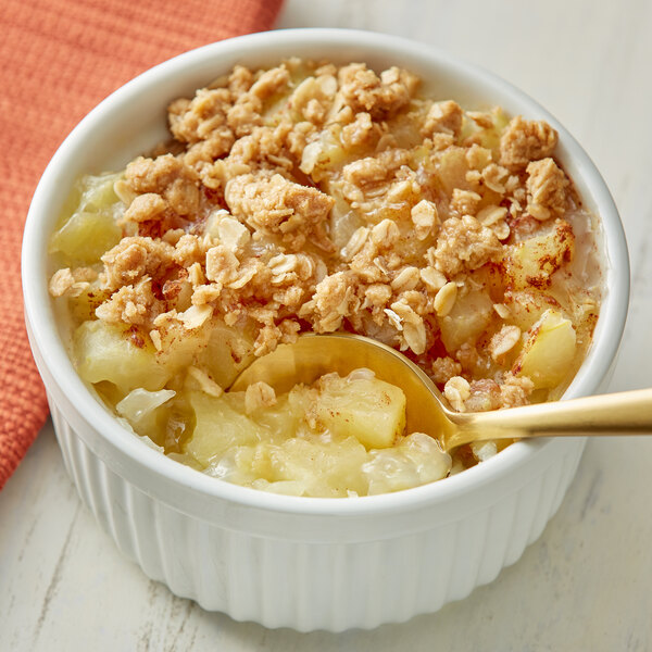 A bowl of Musselman's diced apples and oatmeal with a spoon.