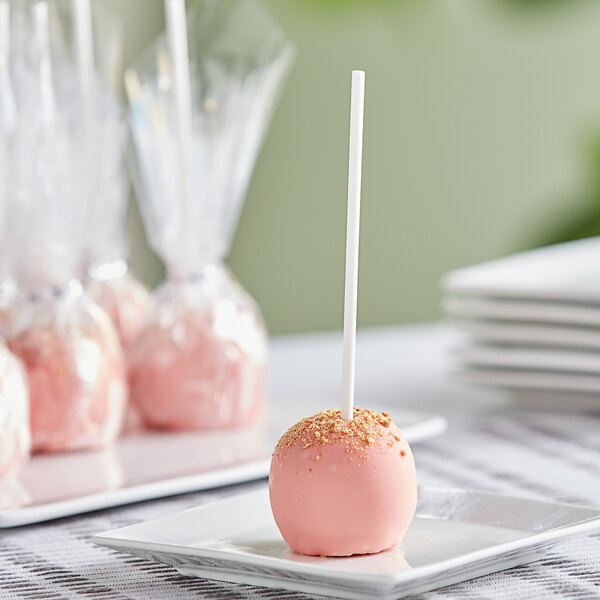 A pink Chalet Desserts strawberry shortcake cake pop on a white plate.