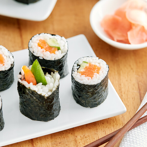 A plate of sushi rolls with a piece of Green Seaweed Sushi Nori on a table.