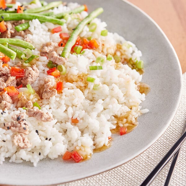 A plate of Fancy Variety Rice with meat and vegetables.