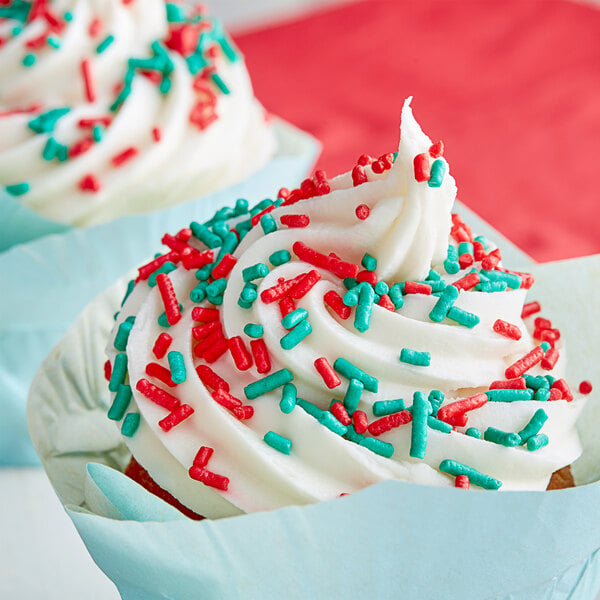 A cupcake with white frosting and red sprinkles.