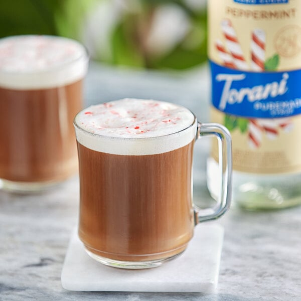 A glass mug of brown liquid with Torani Puremade Zero Sugar Peppermint Flavoring Syrup.