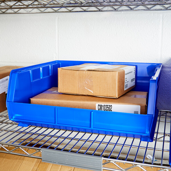 A blue Metro stack bin on a shelf with boxes inside.