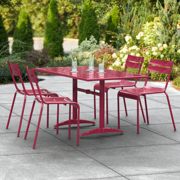 A red Lancaster Table and Seating dining table and chairs on a patio.