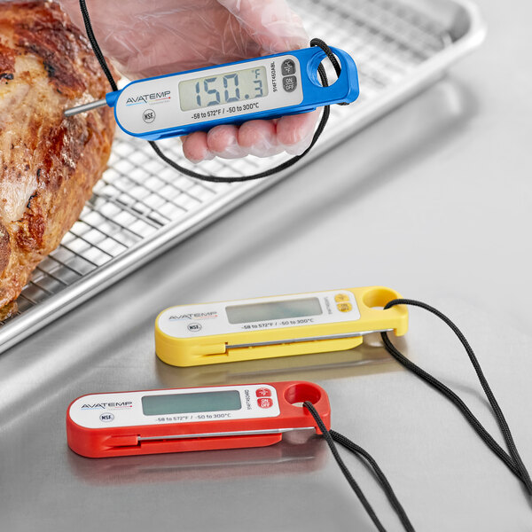 A person using an AvaTemp digital folding probe thermometer to check a piece of meat.