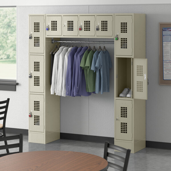 A Regency beige locker with a garment rack and clothes hanging on it.