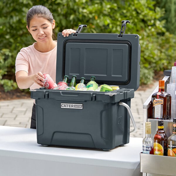 A woman putting drinks in a CaterGator outdoor cooler.
