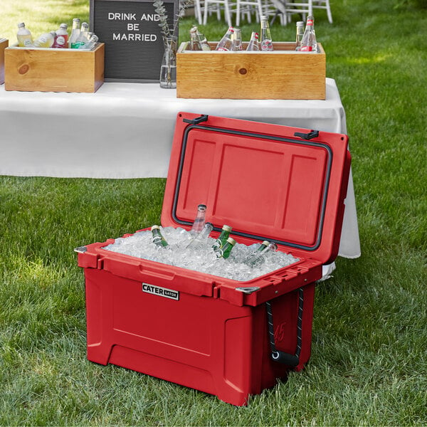 A red CaterGator outdoor cooler with ice and bottles in it.
