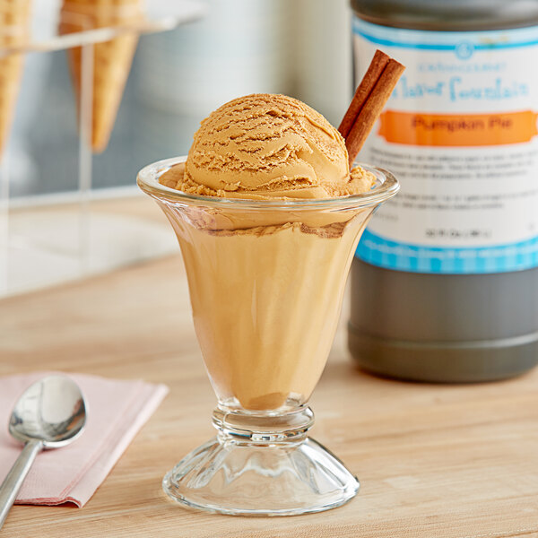 A glass with brown pumpkin pie ice cream in it.