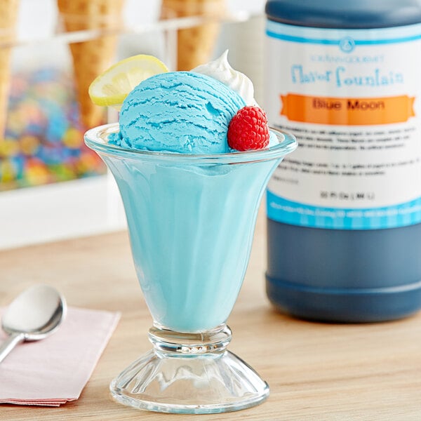 A glass of blue ice cream with a raspberry.
