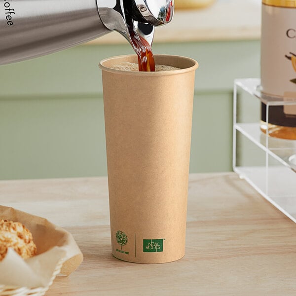 A New Roots Kraft paper hot cup being filled with coffee.