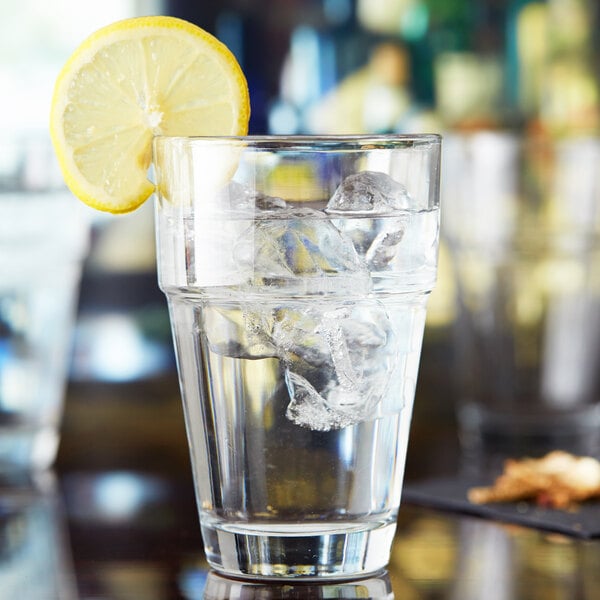 An Anchor Hocking Stackable Beverage Glass filled with water, ice, and a lemon slice.