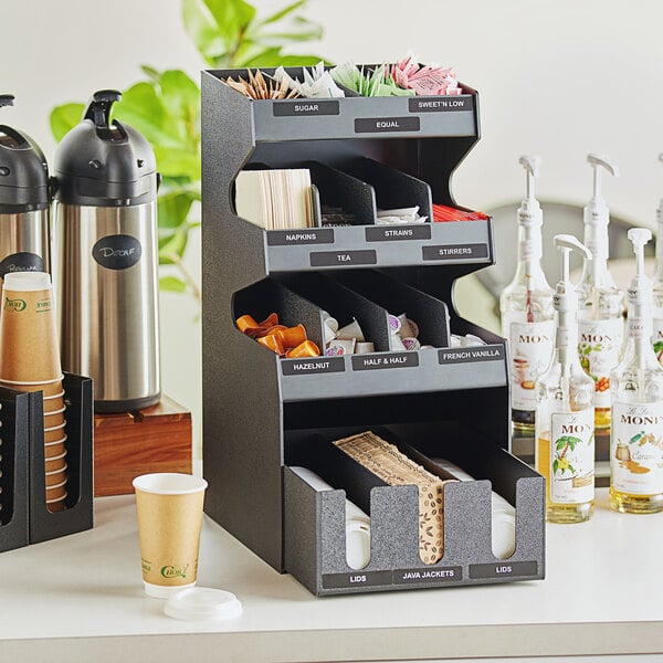 A black ServSense countertop condiment organizer with 15 sections and a bottom drawer.