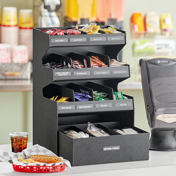 A black ServSense countertop organizer with 15 sections for condiments.