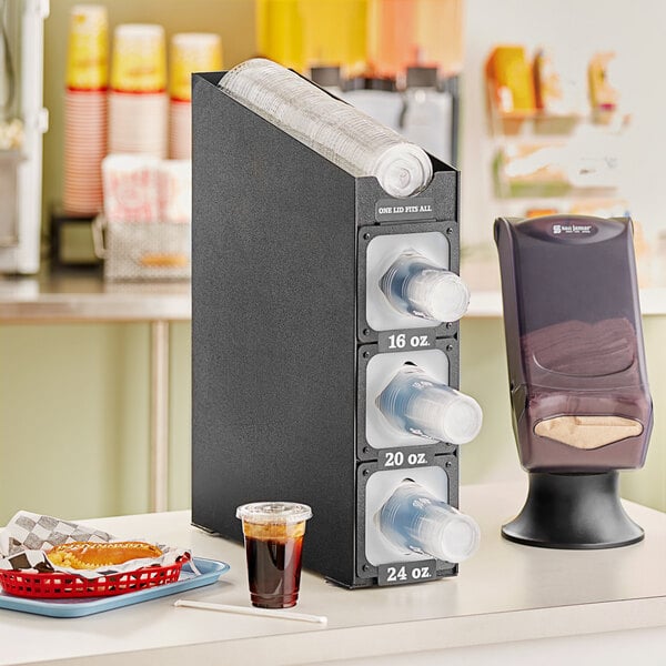 A black KleanTake countertop cup and lid organizer with a straw holder.