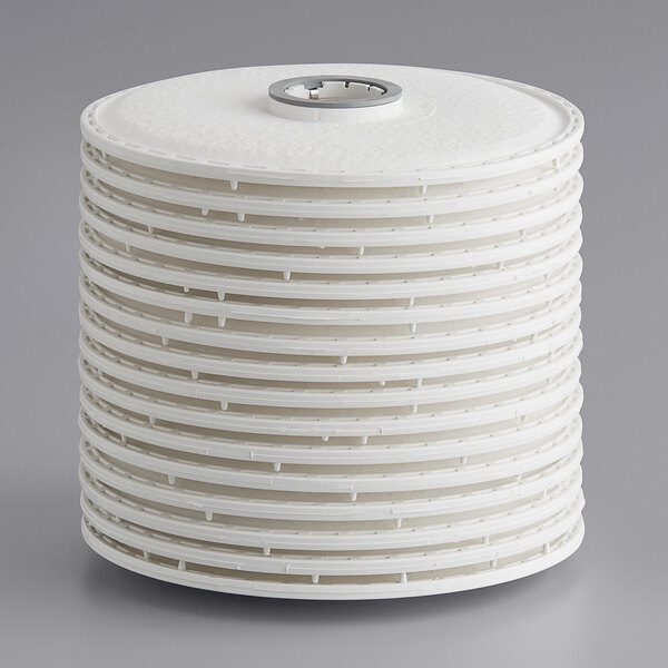 A stack of white plastic discs with a white ceramic filter on top.