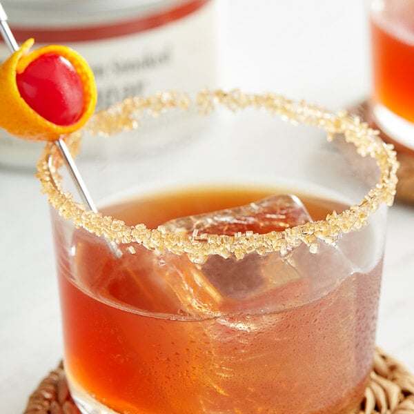 A drink with Bourbon Smoked Sugar on the rim and a cherry on a stick.
