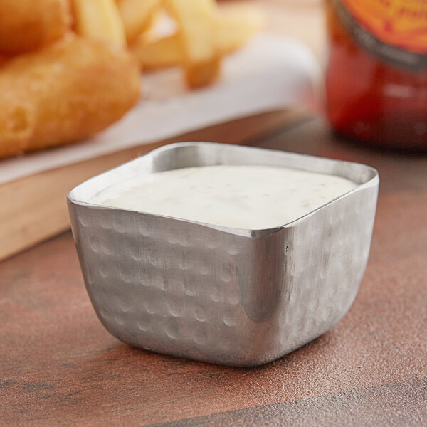 An American Metalcraft square stainless steel sauce cup with white sauce inside.