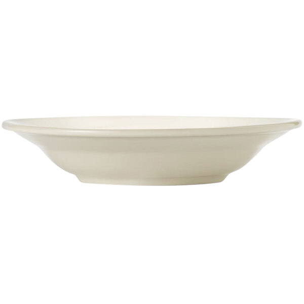 A close up of a Libbey Porcelana cream white porcelain pasta bowl with a wide rim and rolled edge.