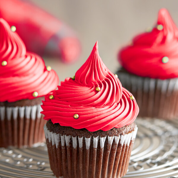 A close-up of a cupcake with red frosting.