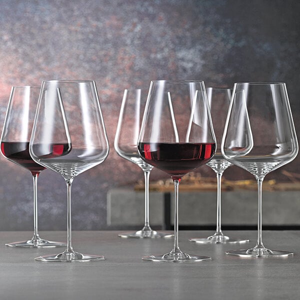 Two Spiegelau Bordeaux wine glasses filled with red wine.