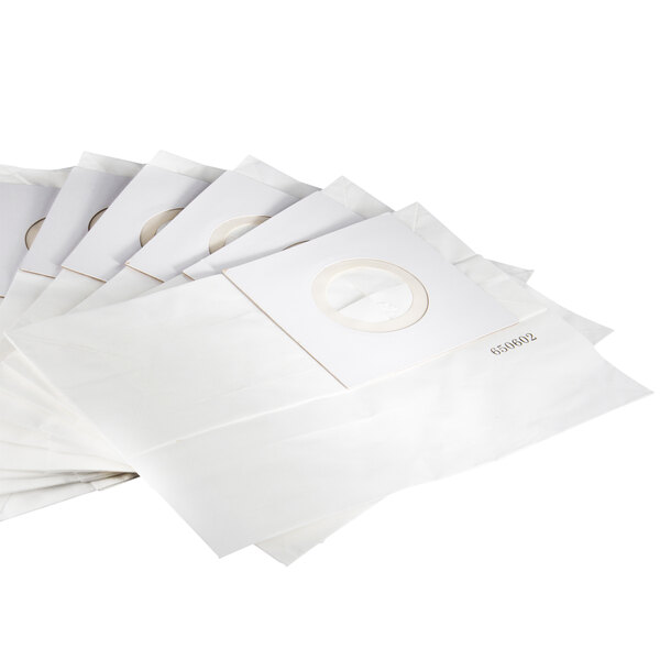 A stack of white paper bags with a white label.