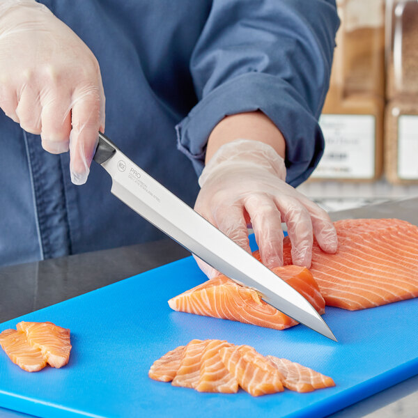 A person in gloves using a Kai PRO Yanagiba knife to cut salmon on a blue cutting board.